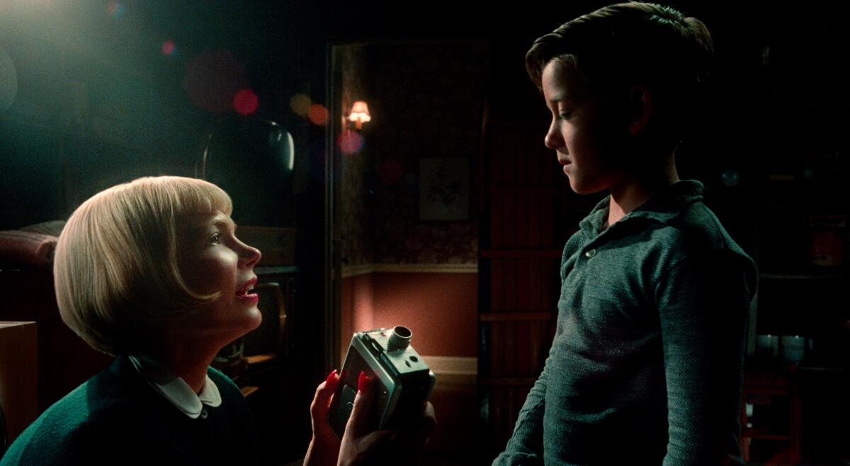Michelle Williams gives her young son a movie camera in a scene from "The Fabelmans."