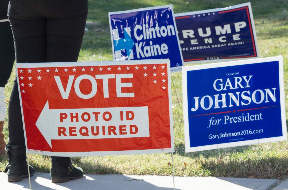 Signs are seen on a lawn near a polling place in Arlington, Va., on Nov. 8.