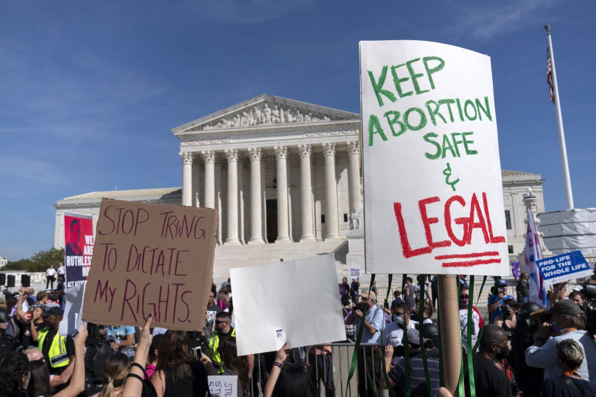 Demonstrators march outside of the the U.S. Supreme Court during the Women's March in Washington, Saturday, Oct. 2, 2021. (AP Photo/Jose Luis Magana)