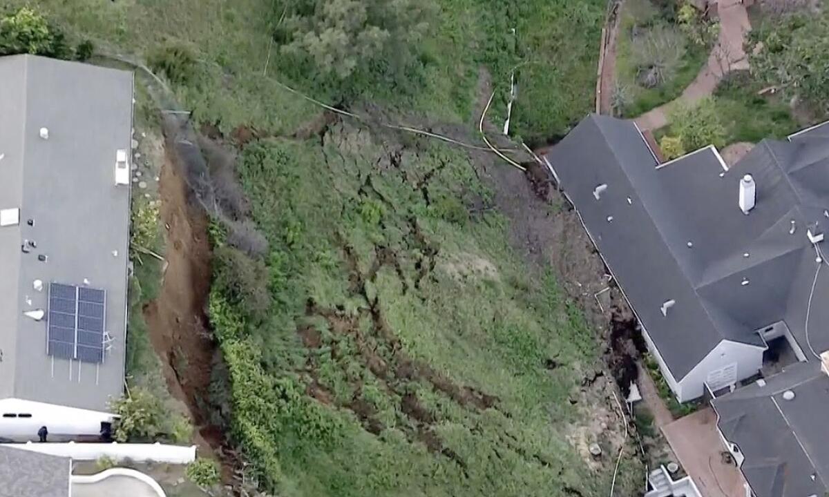 A hillside that has fallen into a home below.
