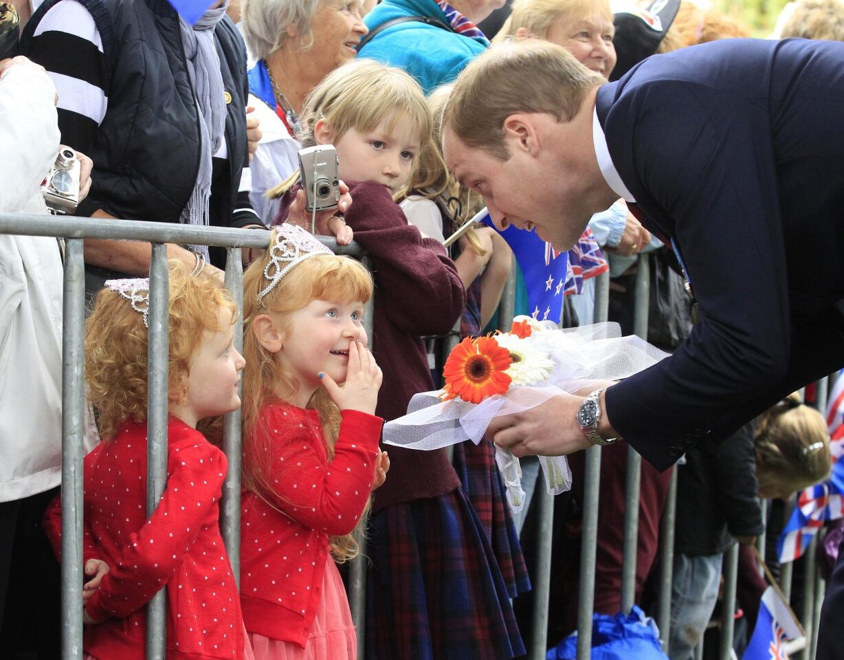 Prince William receives flowers from two little girls during a walkabout in Seymour Square in Blenheim, New Zealand.