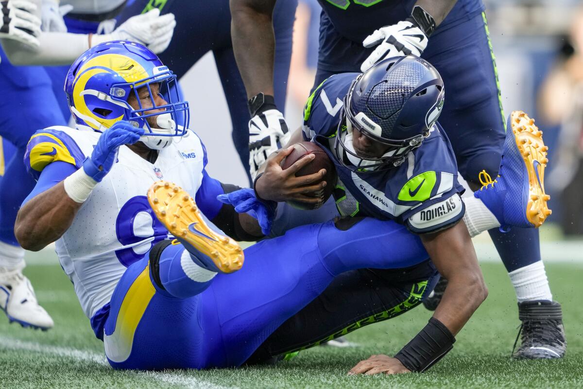 Rams defensive tackle Aaron Donald, left, sacks Seattle Seahawks quarterback Geno Smith in the fourth quarter.