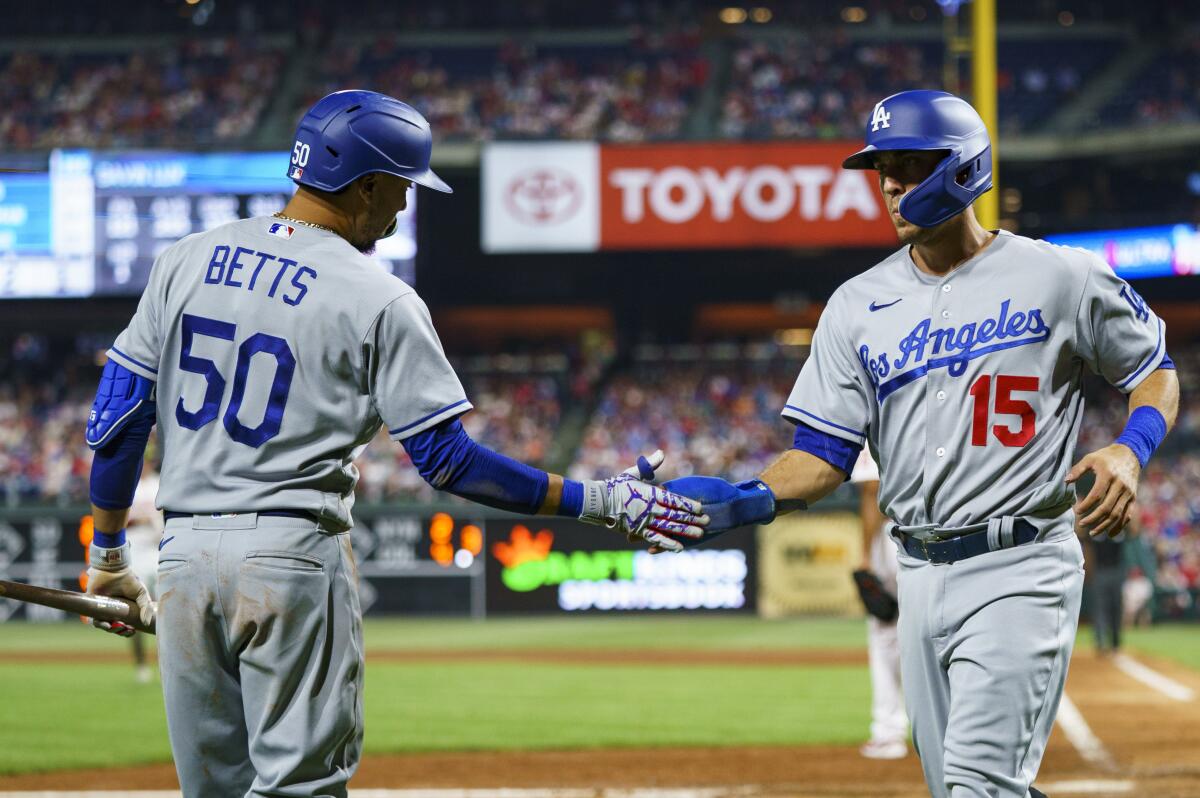 Dodgers Austin Barnes and Mookie Betts slap hands during a game.