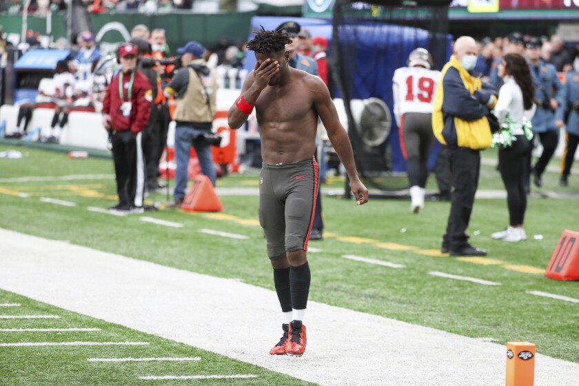 Tampa Bay Buccaneers wide receiver Antonio Brown wipes his face as he leaves the field after throwing his equipment into the stands while his team is on offense during the third quarter of an NFL football game against the New York Jets, Sunday, Jan. 2, 2022, in East Rutherford, N.J. (Andrew Mills/NJ Advance Media via AP)