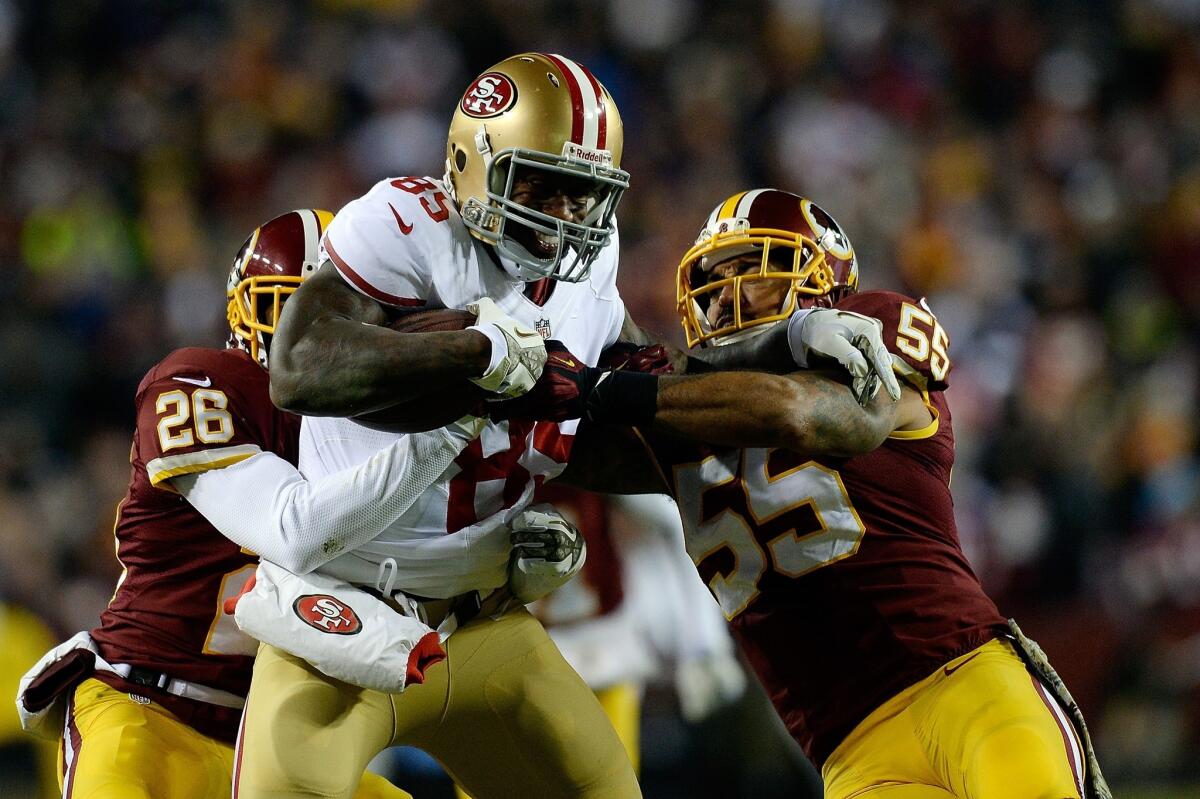 San Francisco tight end Vernon Davis tries to break away from Washington Redskins defenders Josh Wilson, left, and Nick Barnett during the second quarter of the 49ers' 27-6 win Monday night.