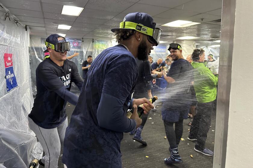 Tampa Bay Rays shortstop Junior Caminero, center, celebrates with teammates after defeating the Boston Red Sox following a baseball game at Fenway Park, Wednesday, Sept. 27, 2023, in Boston. (AP Photo/Jimmy Golen)