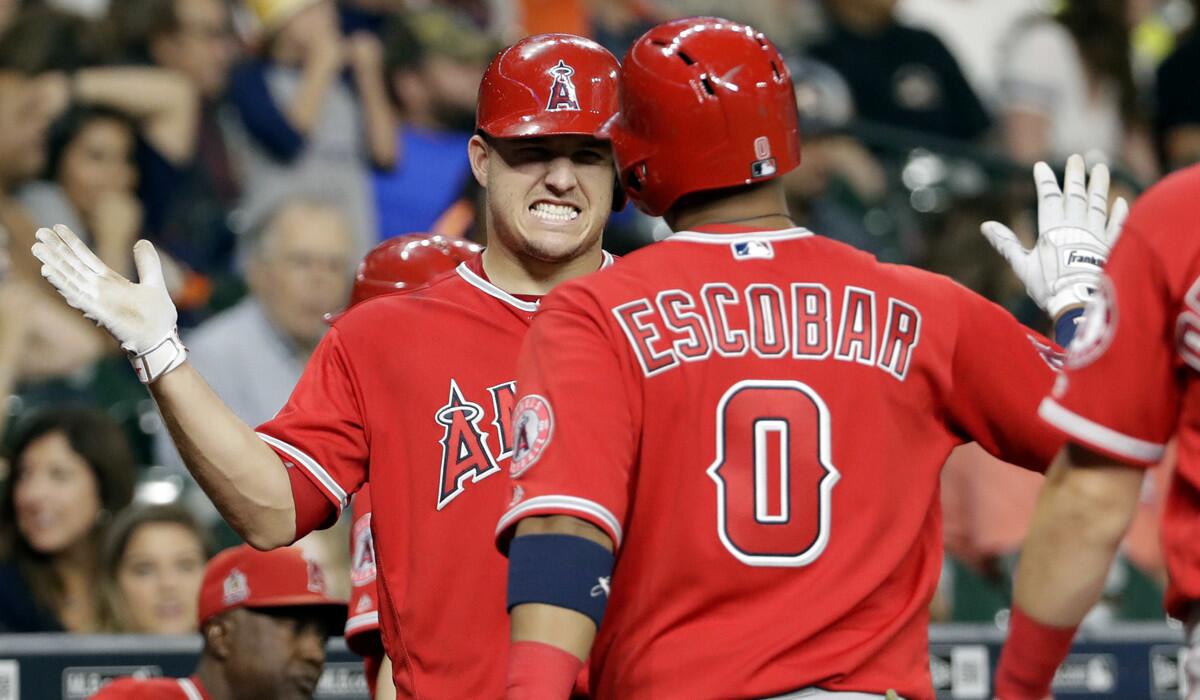 Angels' Yunel Escobar (0) is congratulated by Mike Trout after hitting a two-run home run against the Houston Astros in the ninth inning Friday.