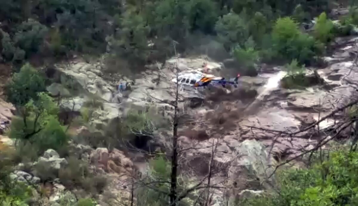Un helicóptero recoge sobrevivientes a la tragedia en que fallecieron al menos nueve miembros de una familia arrastrados por un torrente de agua en el Bosque Nacional Tonto de Arizona.
