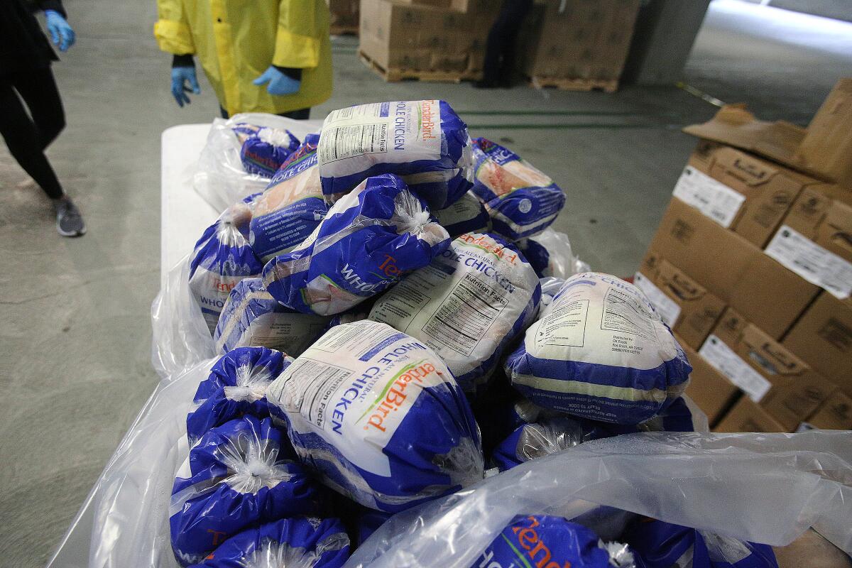 A table with frozen chicken that will be given to people at the drive-through station of the food pantry at Glendale Community College on Tuesday, April 7, 2020.