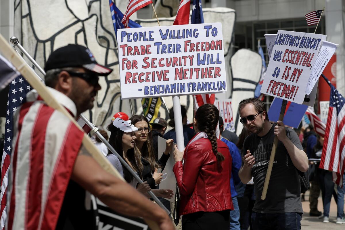 "La gente que está dispuesta a sacrificar su libertad por seguridad no tendrá ninguna de las dos", dice un cartel de una manifestación para protestar los confinamientos del coronavirus en Chicago el 16 de mayo del 2020.