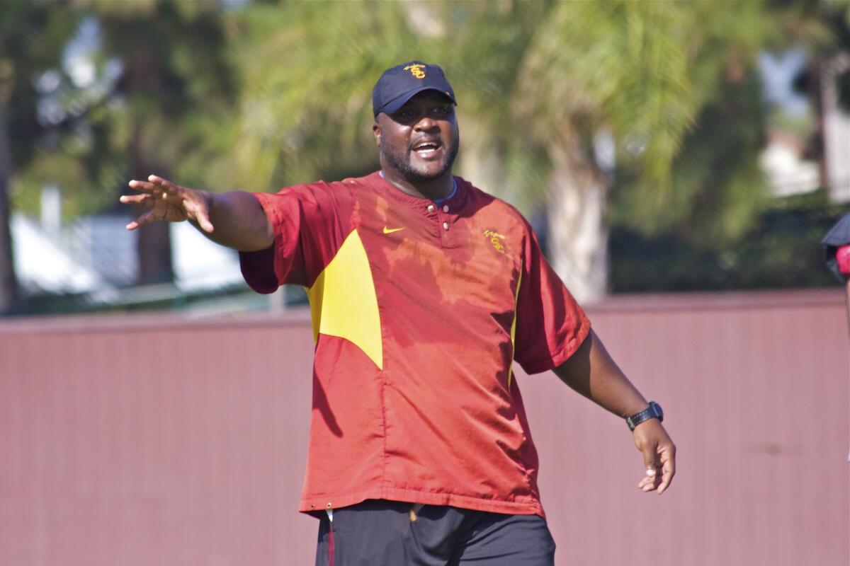 USC assistant Tee Martin shouts instruction to wide receivers group during practice.