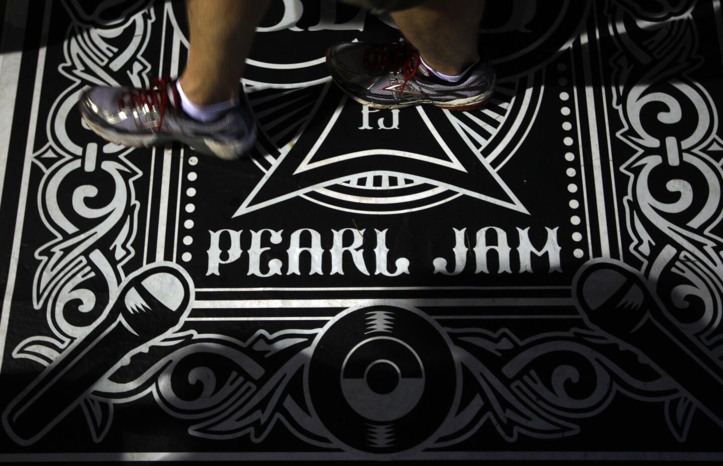 A fan walks on a Pearl Jam designed floor covering while attending the band's 20th anniversary tour at Alpine Valley in East Troy, Wisconsin, on Saturday, September 3, 2011.