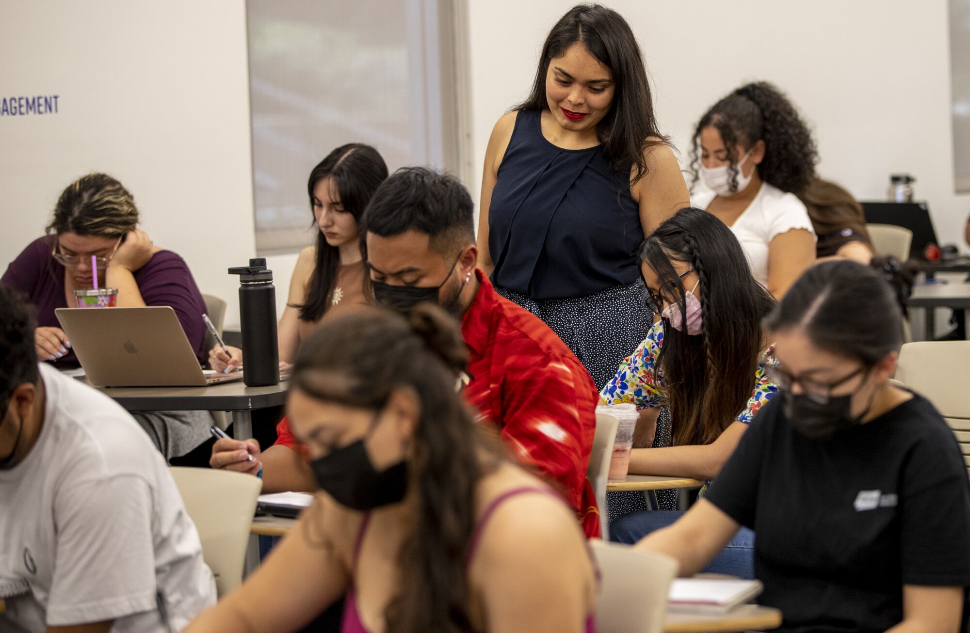 Cindy Escobedo, standing checks on students during a writing exercise at UC Riverside.
