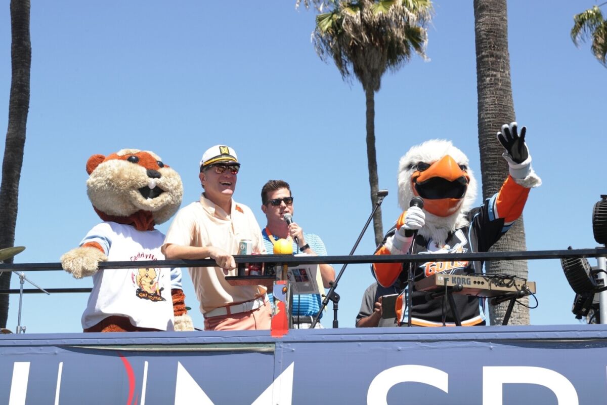 Mascots join event host Ernie Hahn and the auctioneer to welcome players at last year's CaddyHack event.