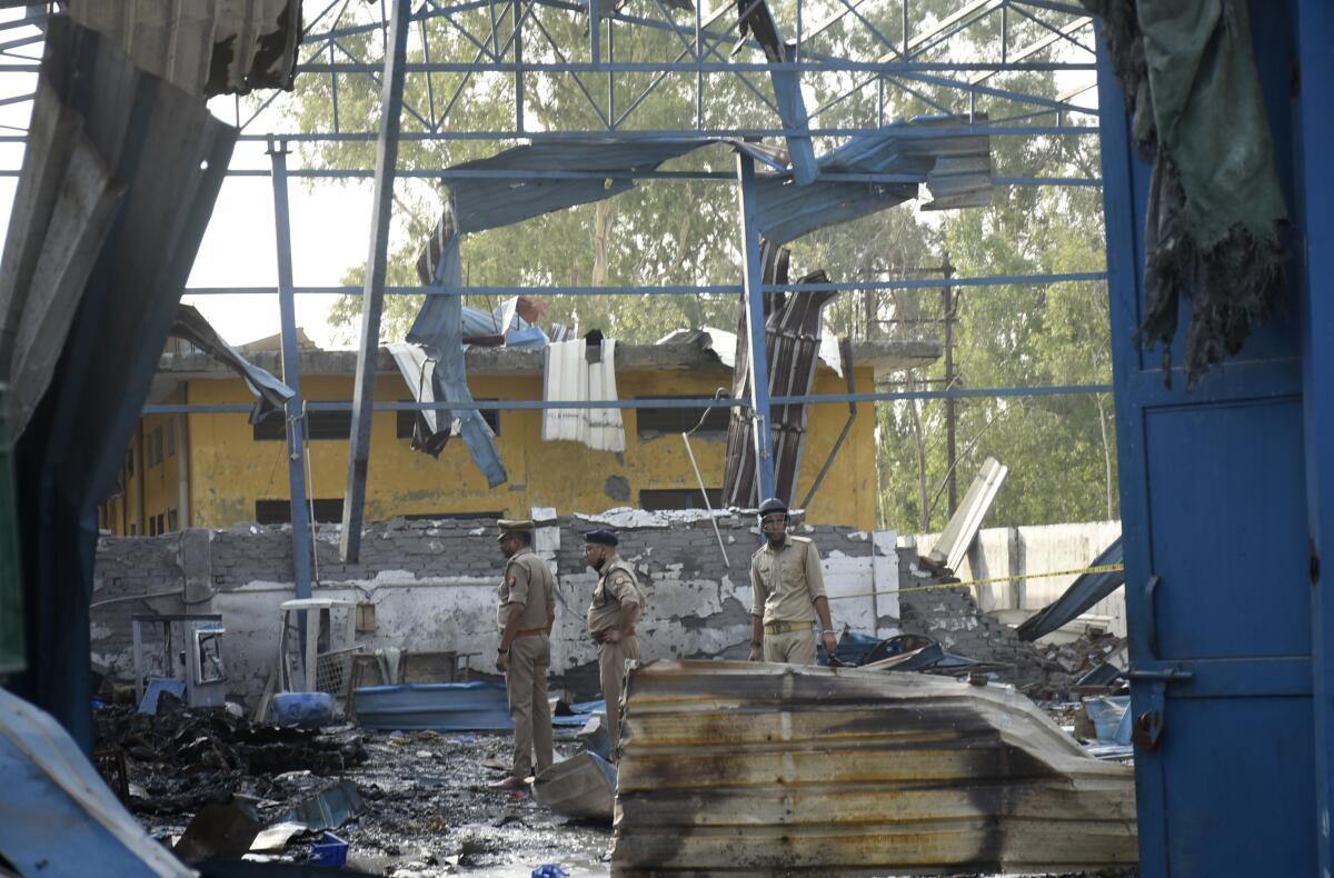 Policemen inspect the site of a fire in Hapur, India, Saturday, June 4, 2022. At least eight workers were killed and more than a dozen others injured after fire erupted in a chemical factory in northern India, police said Saturday. (AP Photo)