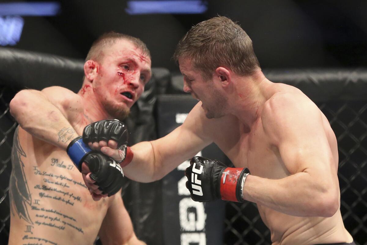 Jason Knight, left, and Chas Skelly trade punches during their UFC 211 bout.