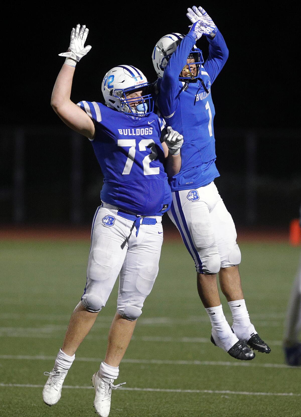 Burbank's Craig Rushton and Isaac Glover celebrate a sack that turns the ball over on downs from Pasadena in a Pacific League football game at Memorial Field in Burbank on Tuesday, September 26, 2019.