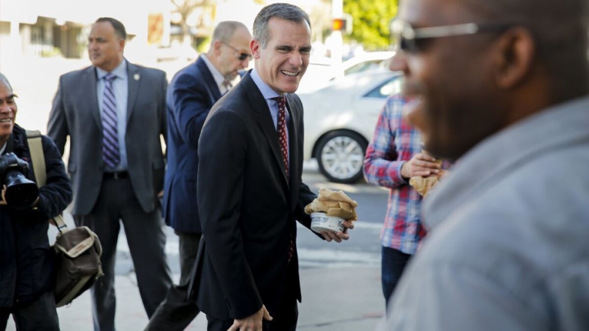 Los Angeles Mayor Eric Garcetti greets Craig Jones, who voted for him, outside the Noah's Bagels in Larchmont Village the morning after a decisive reelection this week.