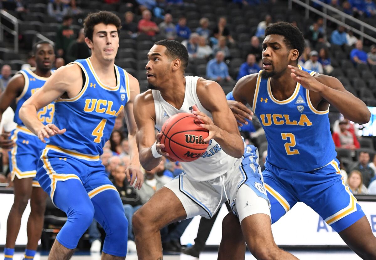 North Carolina's Garrison Brooks drives to the basket between UCLA's Jaime Jaquez Jr., left, and Cody Riley on Saturday in Las Vegas.