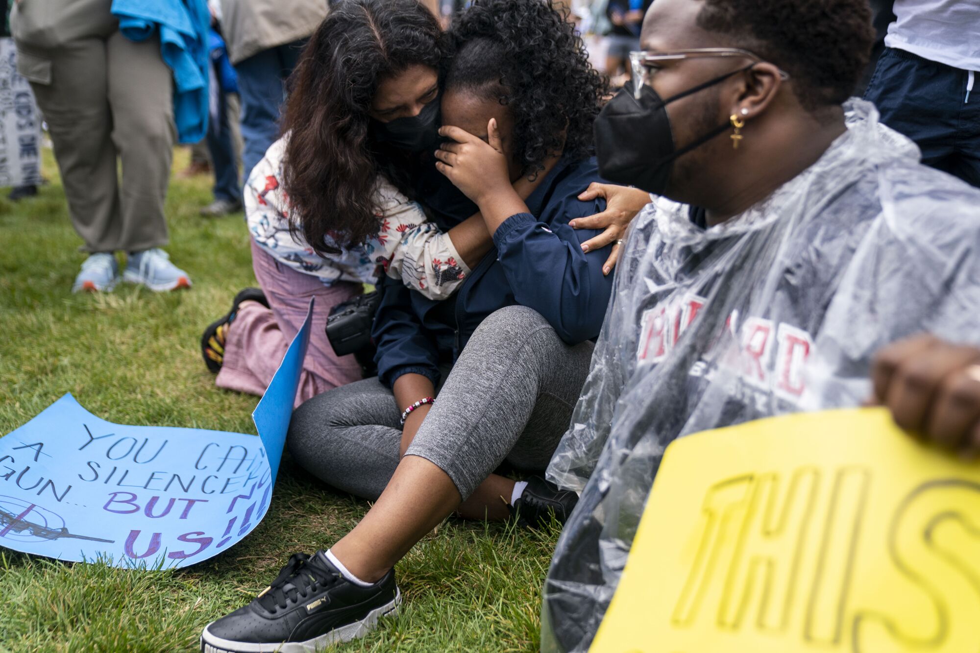 People comfort each other at rally.