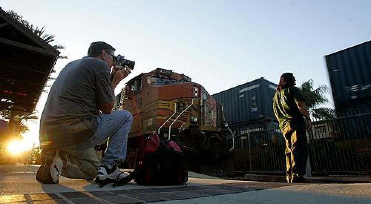 Jeffrey Bass photographs a freight-train brakeman at the Fullerton train station. Bass is among avid rail fans who visit the station regularly to watch and take pictures of the trains. The Chatsworth crash -- and revelations that engineer Robert Sanchez was in contact with rail fans while on the job - stirred an angry backlash against train hobbyists.