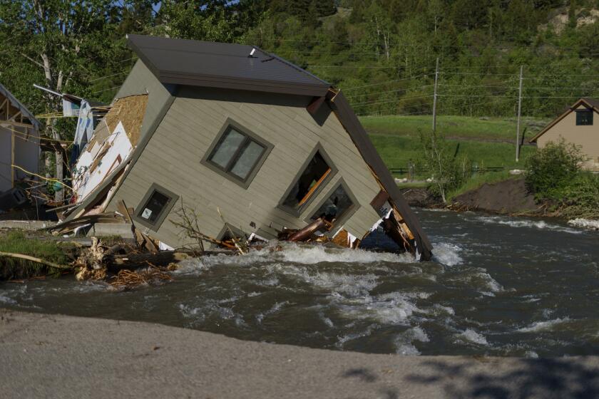FILE - A house sits in Rock Creek after floodwaters washed away a road and a bridge in Red Lodge, Mont., on June 15, 2022. As cleanup from historic floods at Yellowstone National Park grinds on, climate experts and meteorologists say the gap between the destruction in the area and what was forecast underscores a troublesome trend tied to climate change: Modeling programs used to predict storms aren't keeping up with increasingly extreme weather. (AP Photo/David Goldman, File)