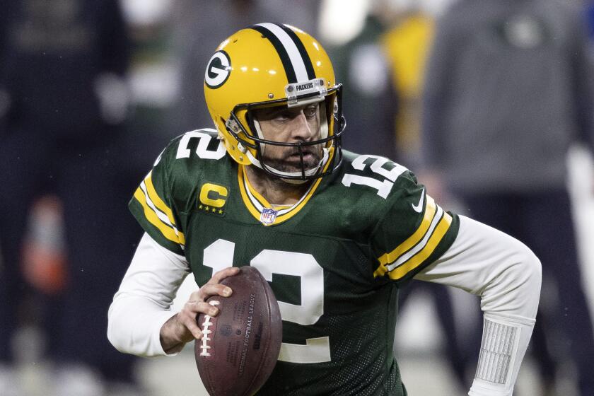 FILE - In this Jan. 16, 2021, file photo, Green Bay Packers quarterback Aaron Rodgers (12) runs during an.