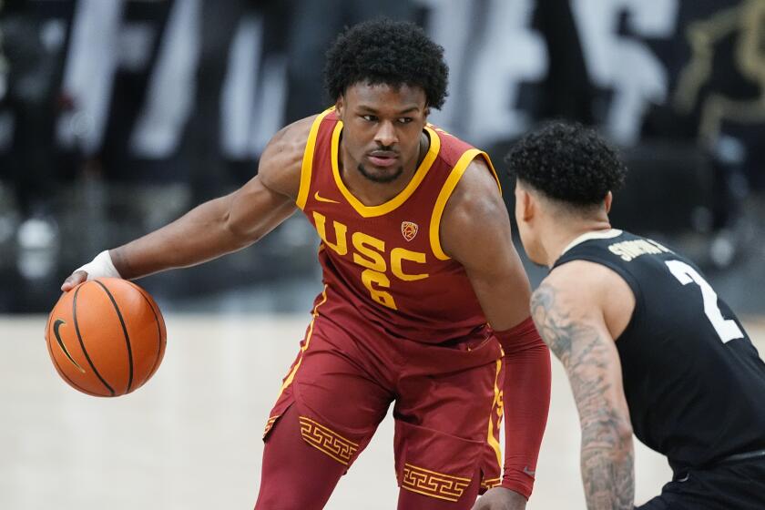 USC guard Bronny James, left, controls the ball in front of Colorado guard KJ Simpson.