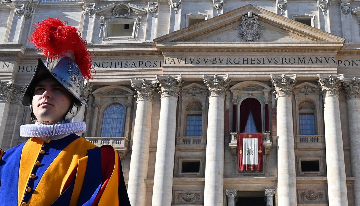 A Swiss guard stands in front of St Peter's Basilica before the appearance of Pope Francis