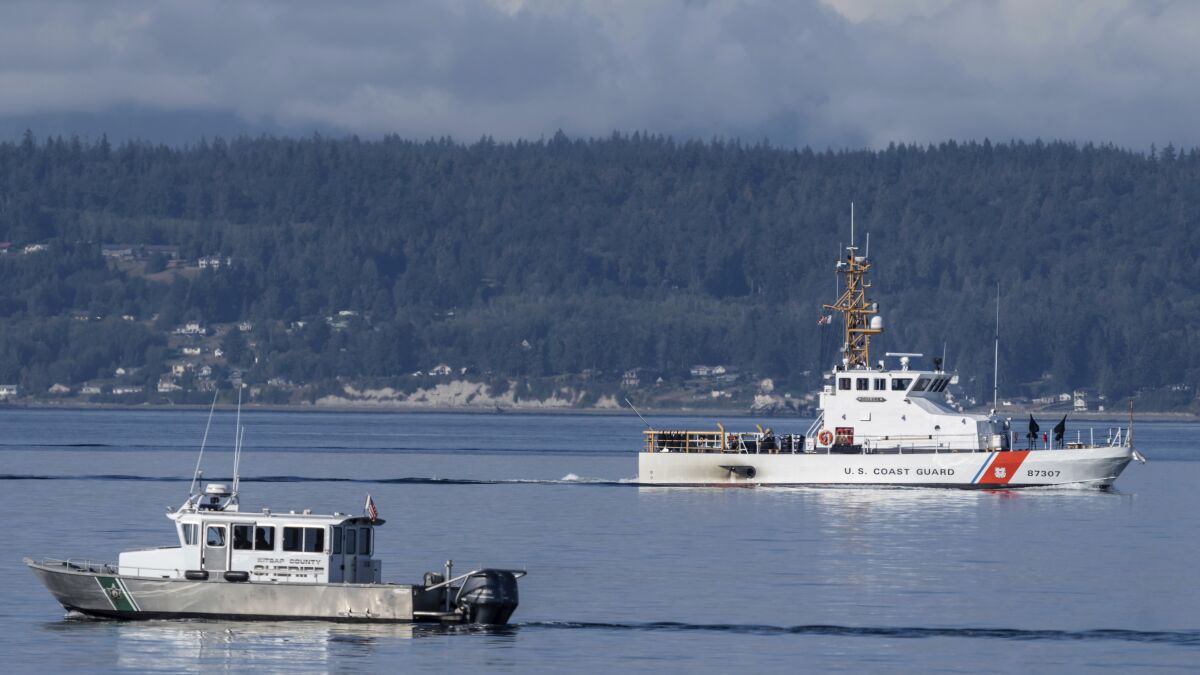 FILE - A U.S. Coast Guard boat and Kitsap, Wash., County Sheriff boat search the area, Monday, Sept. 5, 2022, near Freeland, Wash., on Whidbey Island north of Seattle where a chartered floatplane crashed the day before, killing 10 people. Crews later this month will begin trying to recover the wreckage. rews later this month will begin trying to recover the wreckage of a seaplane that crashed in Puget Sound off Whidbey Island in Washington state. The National Transportation Board said Friday, Sept. 16, 2022 it will work with the Navy to collect the wreckage of the DHC-3 Turbine Otter. (AP Photo/Stephen Brashear, File)