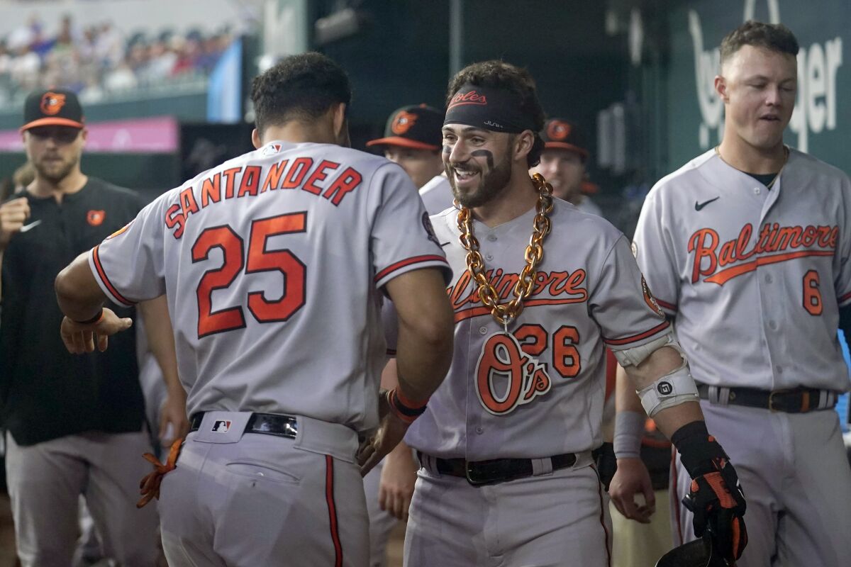 Baltimore Orioles' Anthony Santander (25) and Ryan McKenna, right, celebrate affer McKenna hit a solo home run in the second inning of a baseball game against the Texas Rangers, Wednesday, Aug. 3, 2022, in Arlington, Texas. (AP Photo/Tony Gutierrez)