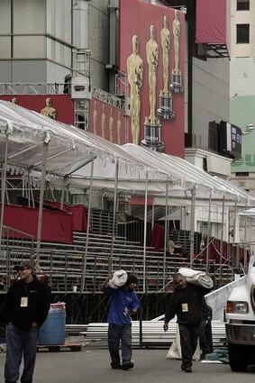 Under cloudy skies, the workers prepare the area outside the Kodak Theatre for the Oscars on Sunday.
