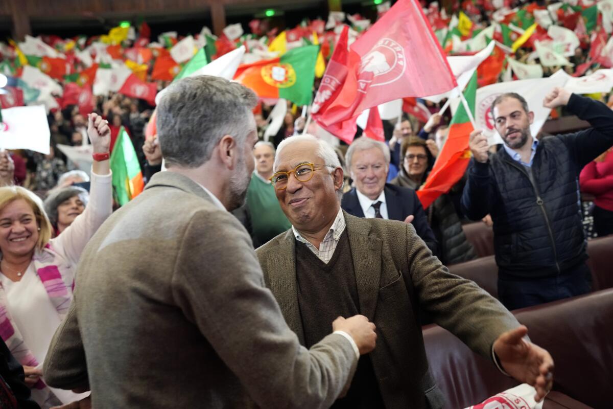Socialist Party leader Pedro Nuno Santos, left, greets Portuguese Prime Minister Antonio Costa in front of a crowd.