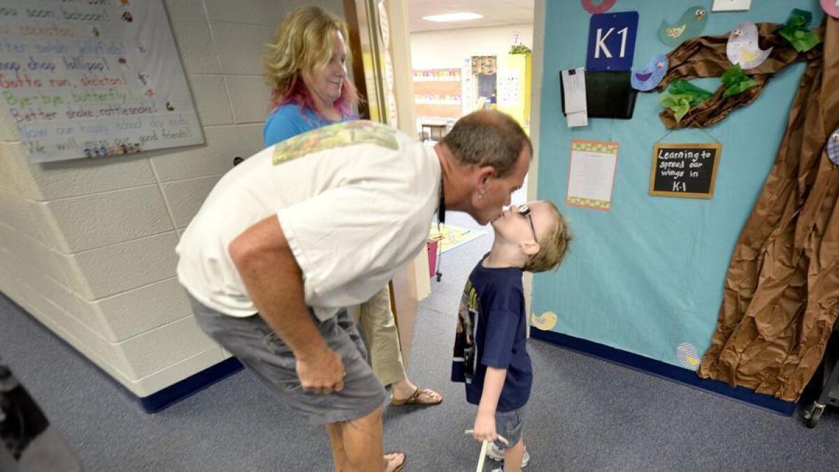 Un nuevo estudio muestra que los estudiantes se benefician de la buena comunicación entre padres y maestros. Shane Warren le da un beso a su hijo Miles de 5 años, mientras lo deja en su primer día de clases en una escuela de North Augusta en S.C., la mamá DeAnne los mira.