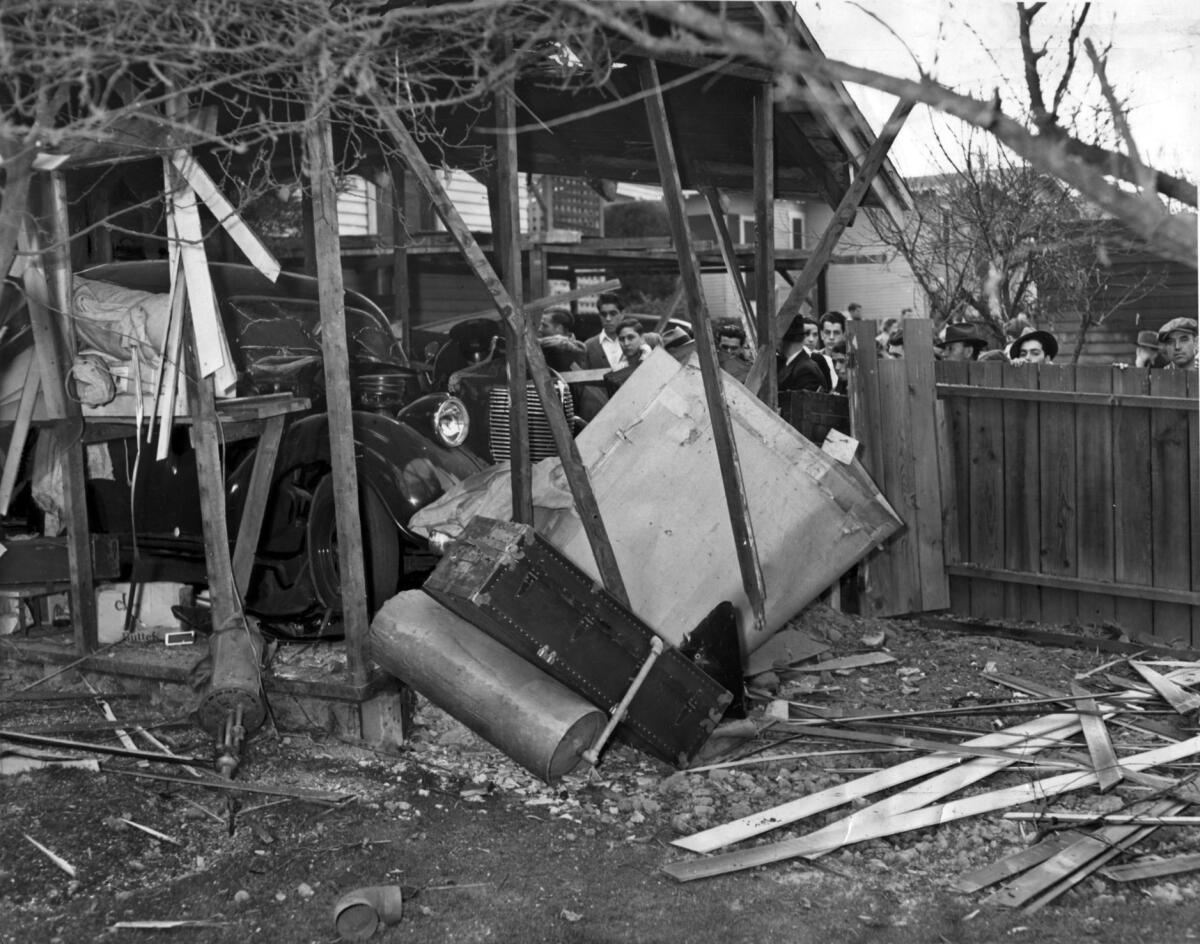 A view of Harry Raymond's garage shows the the damage done by a bomb: doors blown off and the car's hood through the roof.