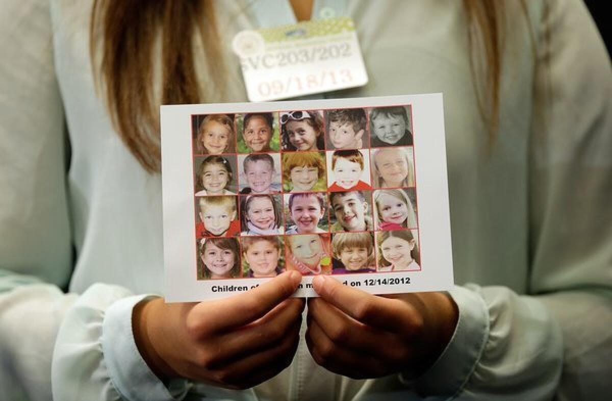 Kyra Murray holds a photo with victims of the shooting at Sandy Hook Elementary School during a press conference at the Capitol calling for gun reform legislation.