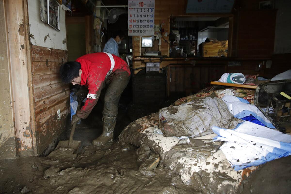 Yoshiki Yoshimura, 17, cleans his home Oct. 15 in Nagano, Japan. The number of deaths tied to Typhoon Hagibis climbed to 53 and was expected to rise.