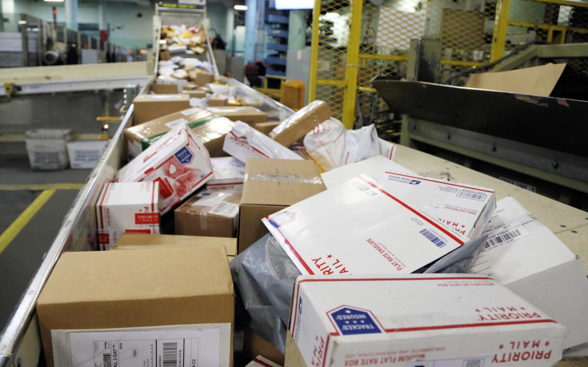 Packages travel on a conveyor belt for sorting at the main post office in Omaha, Neb., on Dec. 14, 2017.