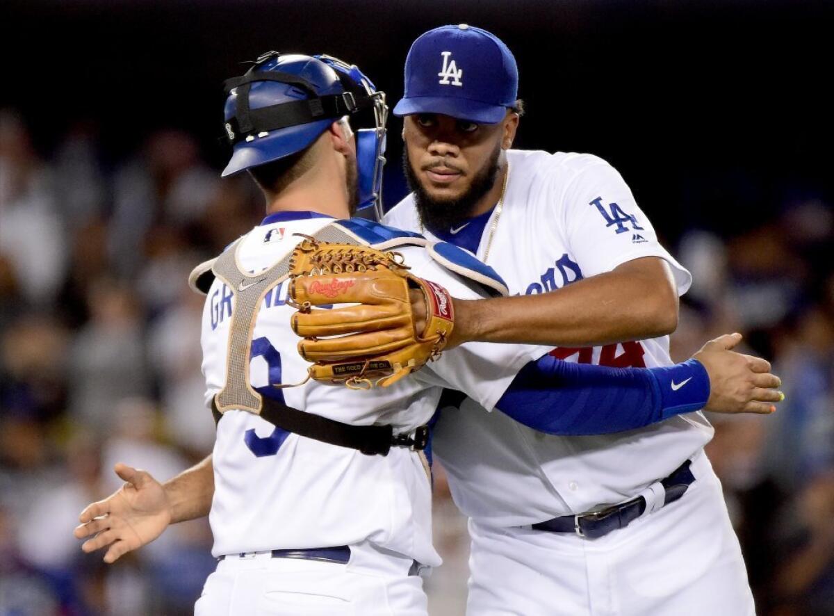 Dodgers closer Kenley Jansen and catcher Yasmani Grandal celebrate a 3-1 victory over the Cincinnati Reds on May 25.