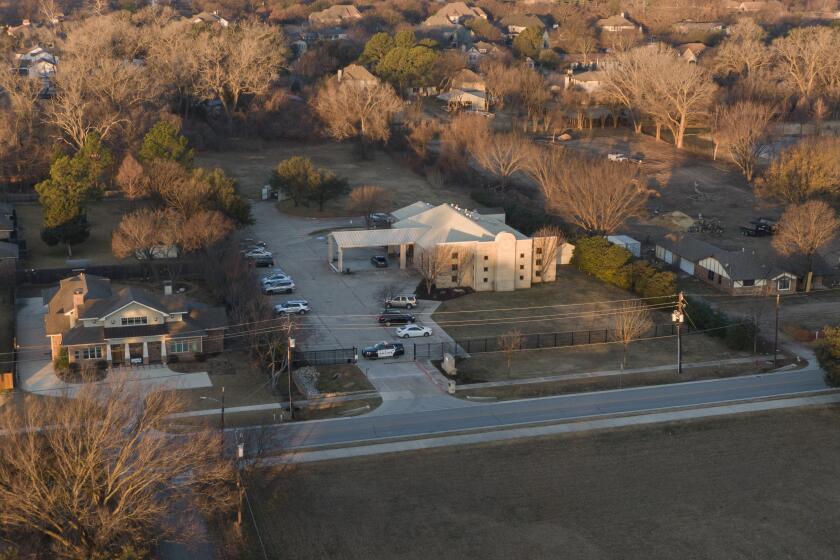An aerial view of police standing in front of the Congregation Beth Israel synagogue, Sunday, Jan. 16, 2022, in Colleyville, Texas. A man held hostages for more than 10 hours Saturday inside the temple. The hostages were able to escape and the hostage taker was killed. FBI Special Agent in Charge Matt DeSarno said a team would investigate "the shooting incident." (AP Photo/Brandon Wade)