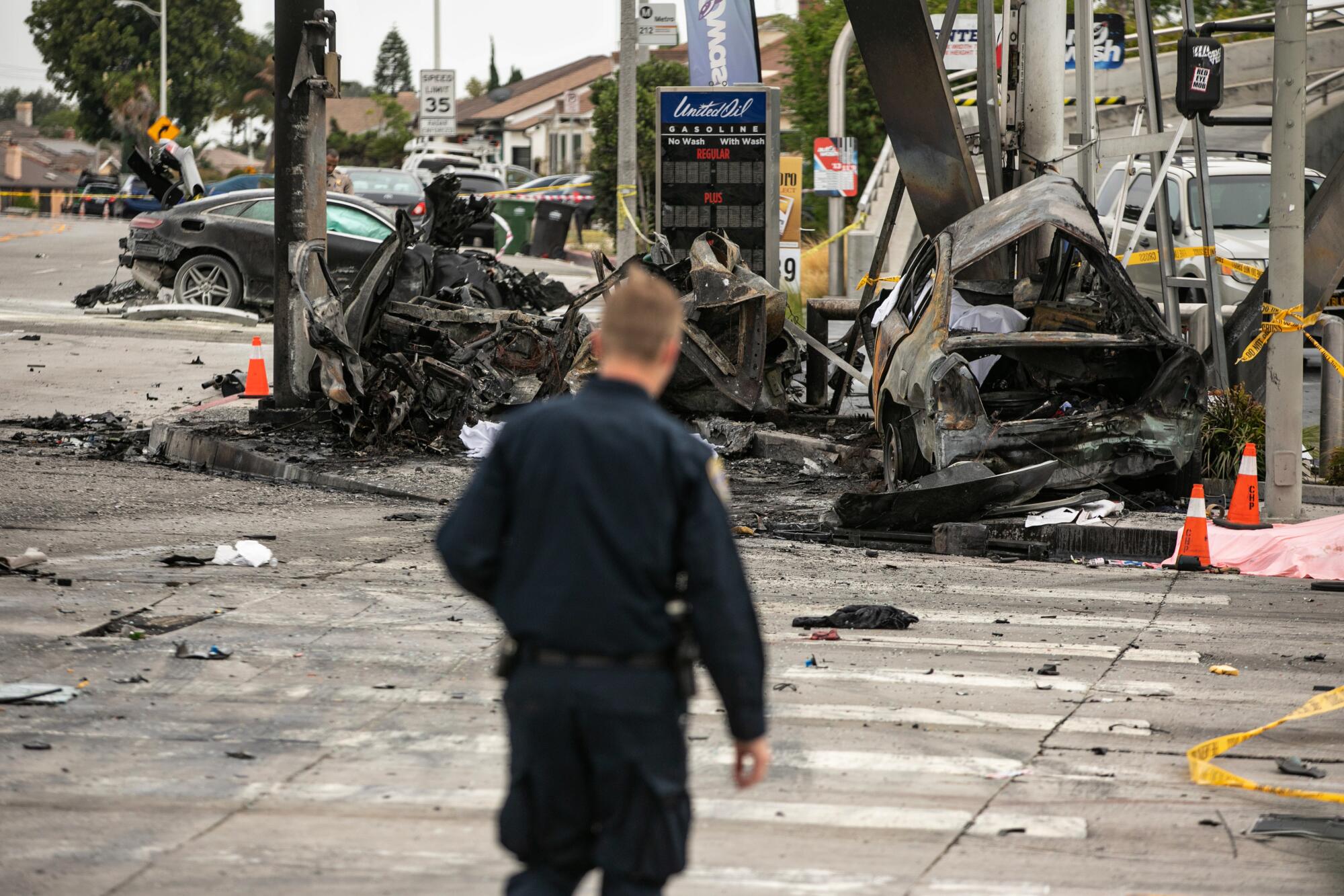 An officer looks over the scene of a fiery crash.