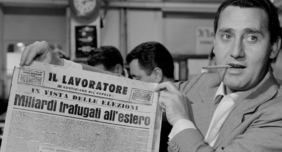 black and white photo of a man smoking a cigarette and holding up an Italian restaurant 