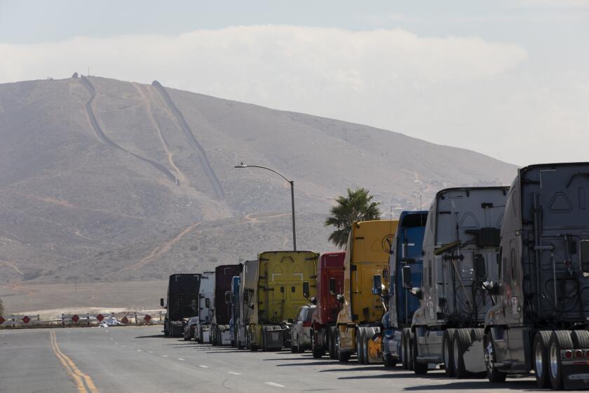 Otay Mesa, CA - September 23: A line of semi-trailer trucks line Enrico Fermi Place, a street minutes away from the Otay Mesa Port of Entry on Thursday, Sept. 23, 2021 in Otay Mesa, CA. Recently, the city of Otay Mesa has seen a growth in industry and future plans for multistory residential homes. Constant traffic comes with industrialization of the city. (Ana Ramirez / The San Diego Union-Tribune)