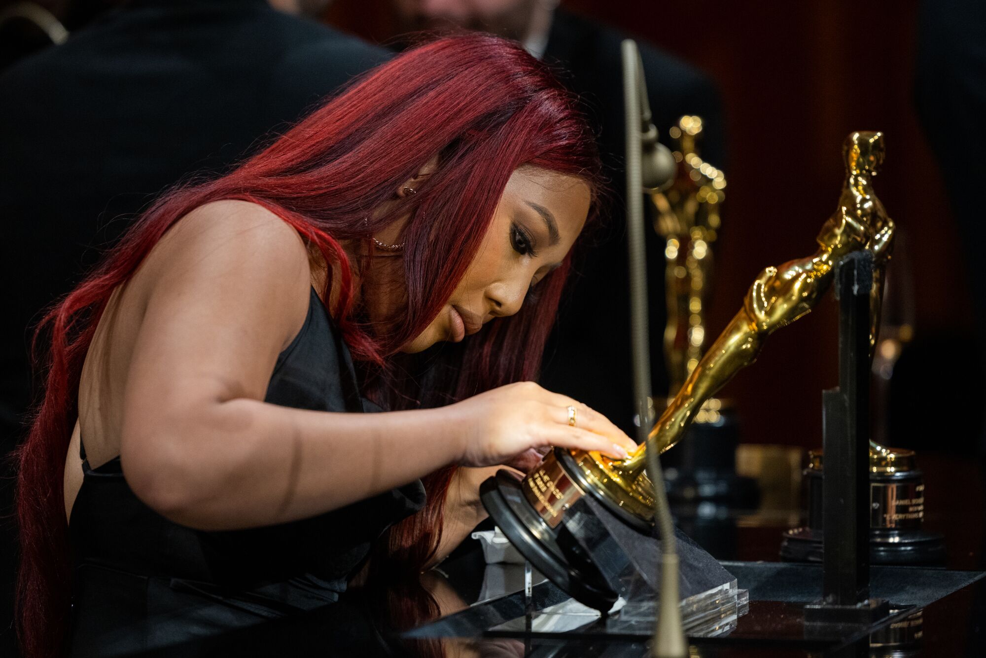 An engraver etches Ke Huy Quan's Oscar at the Governors Ball.