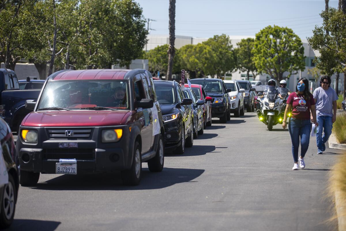 Cars with immigration reform advocates line up during a rally.