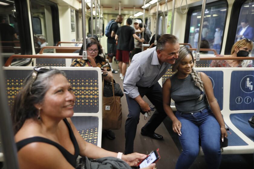 Los Angeles, CA, Wednesday, August 24, 2022 - Mayoral candidate Rick Caruso poses for a photo with LACC student Cassondra Cabrera while they ride the LA subway through downtown. (Robert Gauthier/Los Angeles Times)