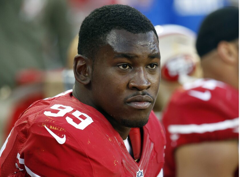 Former San Francisco 49ers linebacker Aldon Smith sits on the bench during an NFL football game in Santa Clara in 2014. The Oakland Raiders on Friday signed the pass rusher, who has been charged in a hit-and-run incident.