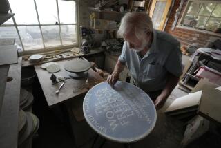 Ned Heywood fettling the glaze on the clay plaque during the making of an English Heritage Blue Plaque, at Heritage Ceramics, The Workshop Gallery in Chepstow, Wales Wednesday, Sept. 6, 2023. English Heritage is preparing to unveil its 1,000th blue plaque, the famous discs that dot the walls of buildings throughout London, marking the places where scientists, artists, politicians and activists have made history. The charity is working to broaden the program to include more women, people from minority ethnic backgrounds and community groups so that it better reflects the diversity of the capital. (AP Photo/Kirsty Wigglesworth)