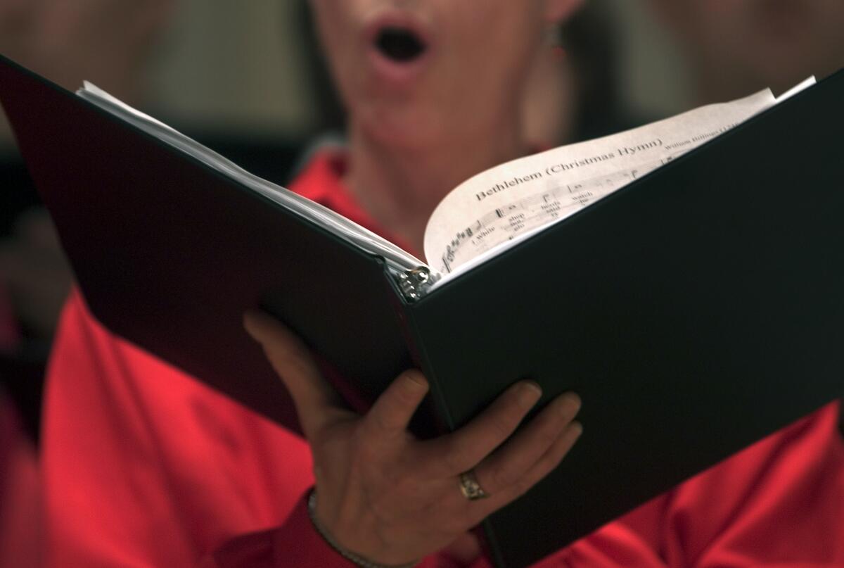A choral singer holding music 