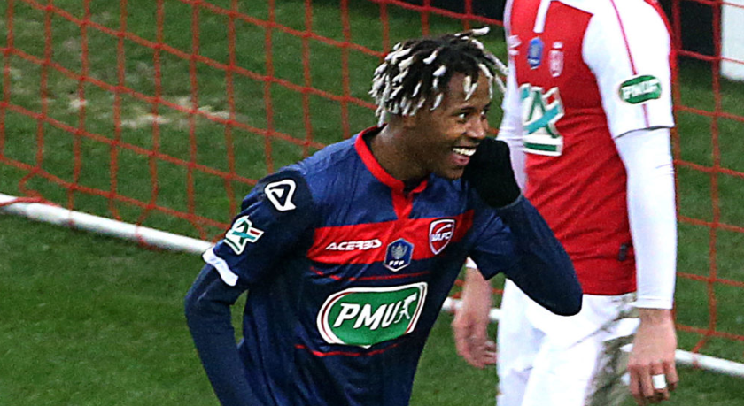 Un futbolista vestido de Valenciennes sonríe.